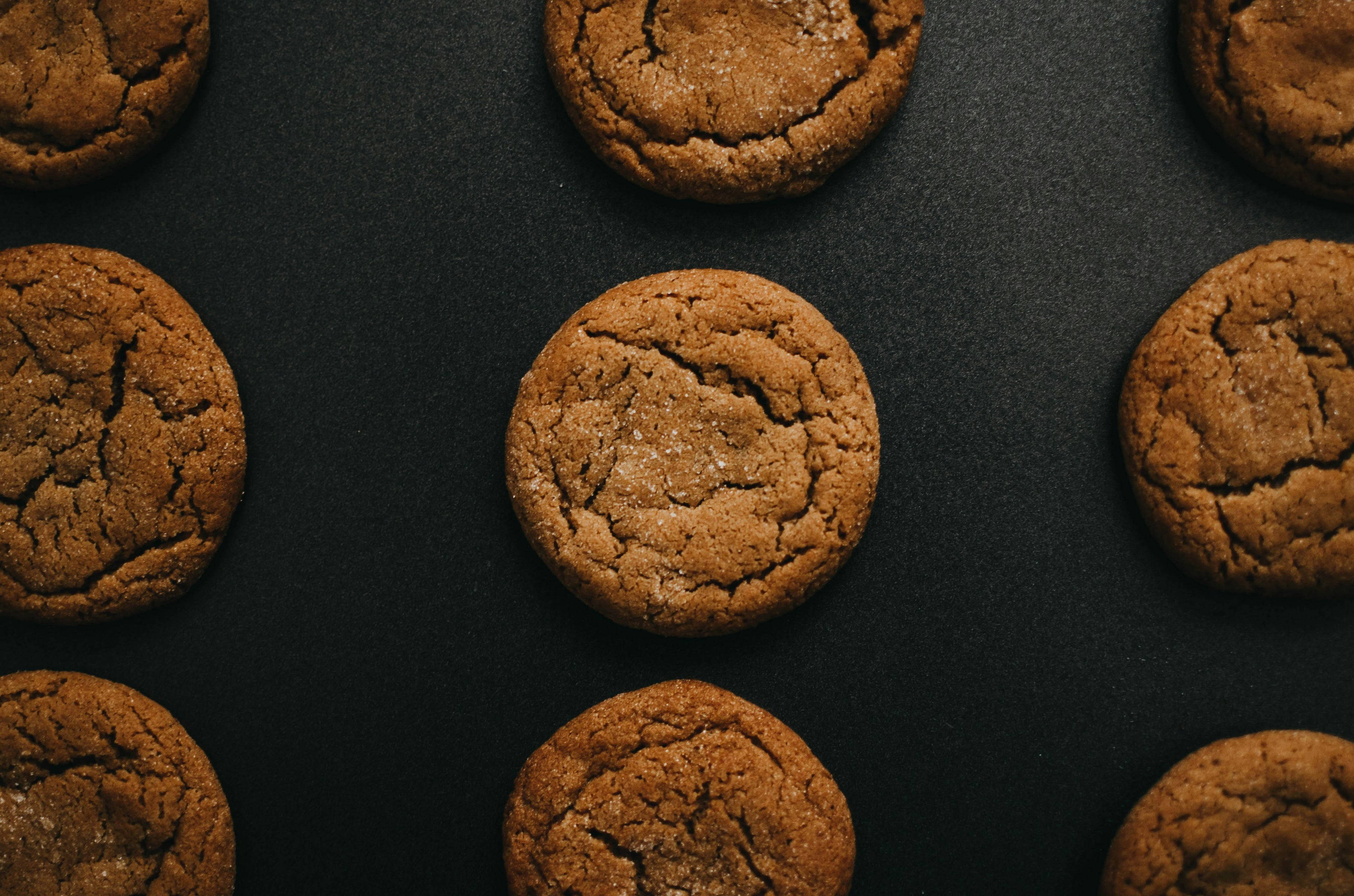 Brown cookies arranged in a grid on a dark surface